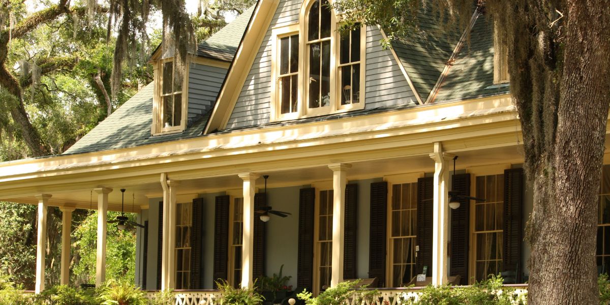 Classic Southern home with a pitched roof and a large front porch surrounded by trees
