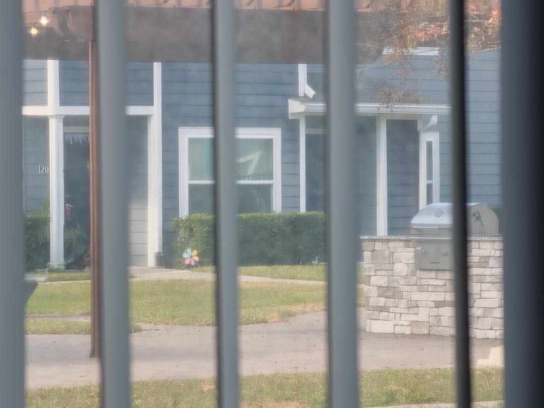 Man who looks like a contractor holds a clipboard while standing at the front door of a suburban home, representing an uns...
