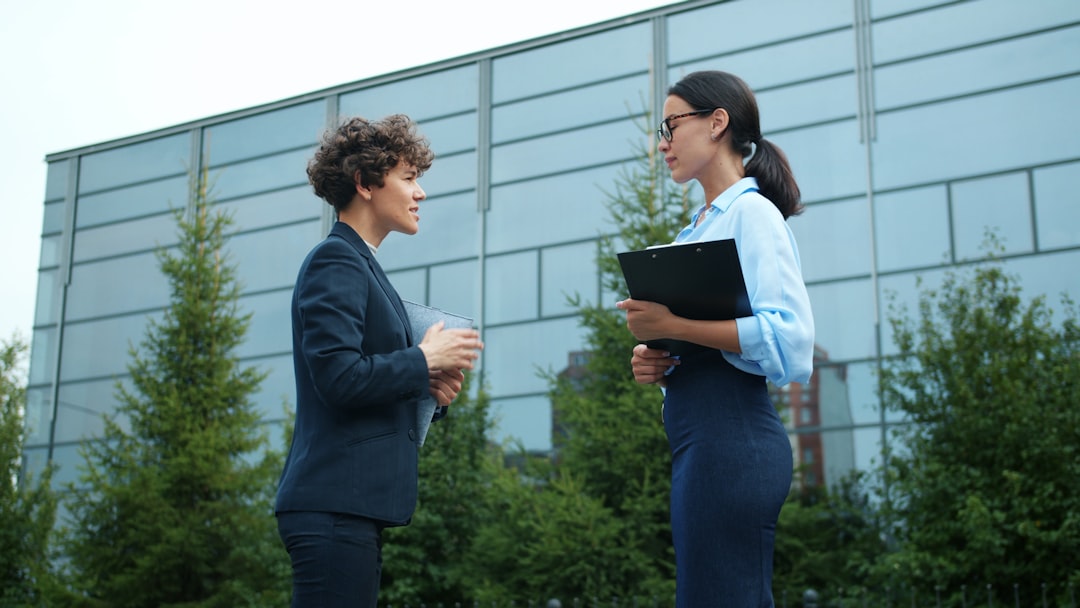 A clean, bright photo of two professionals shaking hands over a set of architectural blueprints on a desk, signifying a successful deal and winning a new construction project.